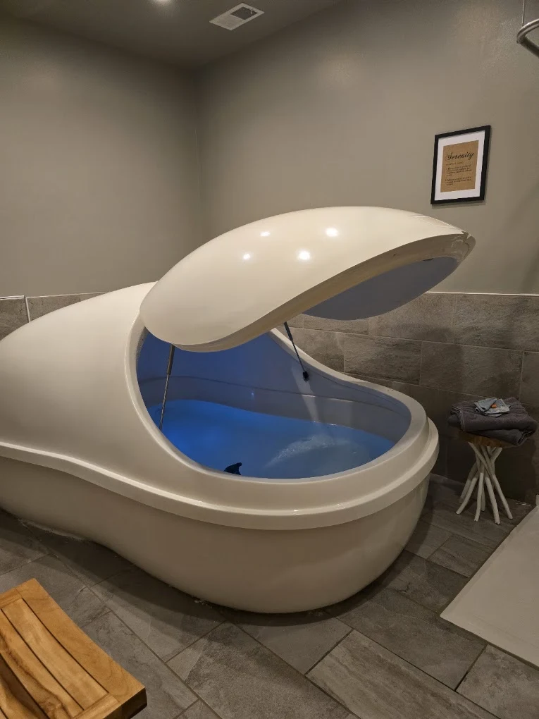 A float pod with its lid open at Serenus Float & Wellness in Bloomington, Indiana