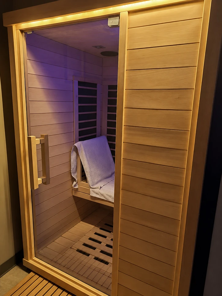 The wood-lined infrared sauna with its glass door at Serenus Float & Wellness in Bloomington, Indiana